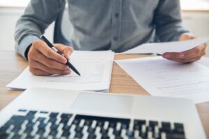 Man working at his laptop and reading through documents